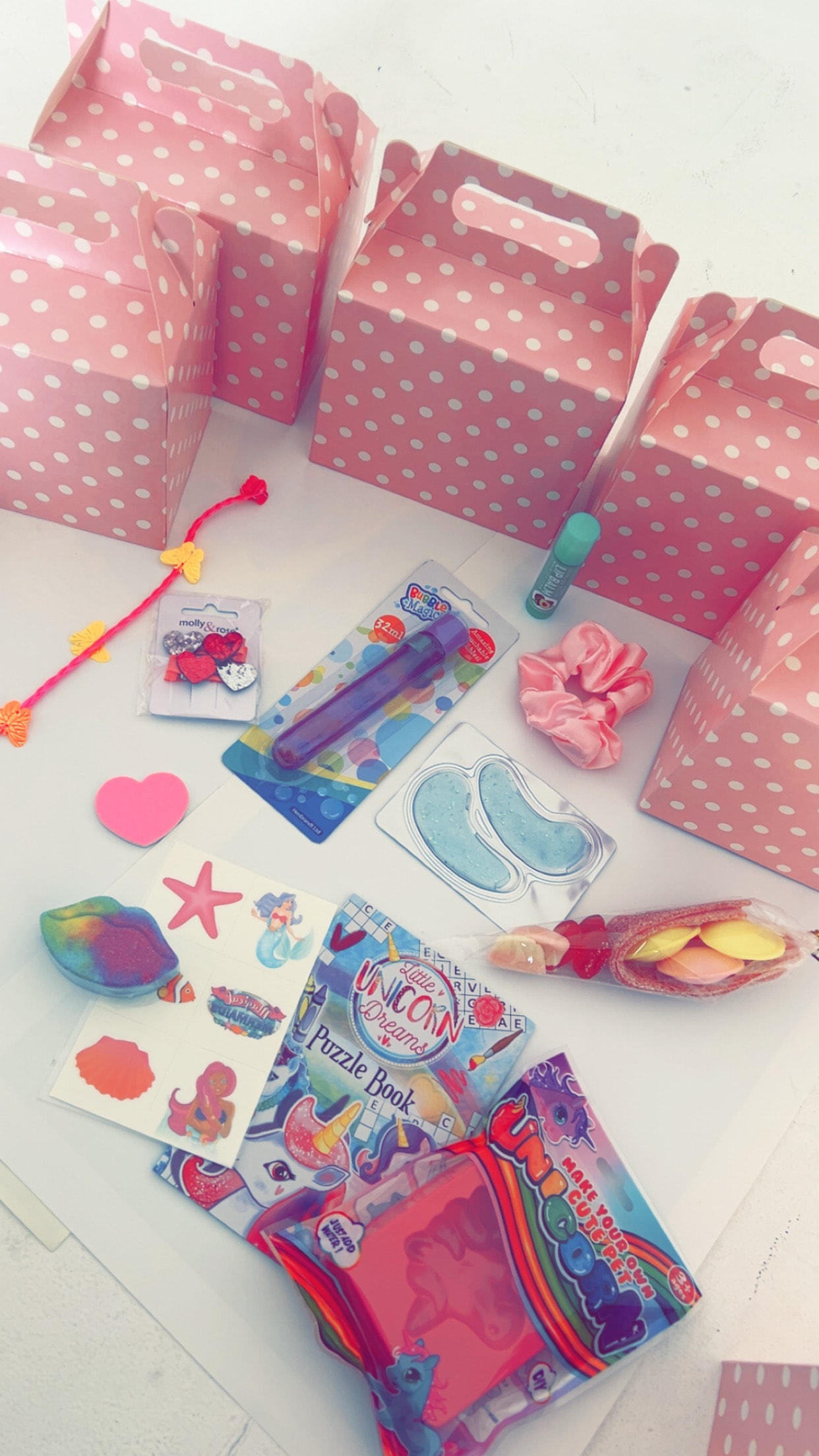 Pink polka-dot party boxes with pamper goodies including scrunchies, eye masks, stickers and sweet treats